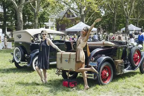 Две женщины позируют у машины на вечеринке The Jazz Age Lawn Party на Губернаторском острове.