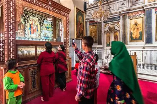 Коптская семья посещает святыню в монастыре Дейр аль-Мухаррак, также называемом Сожженным монастырем. Будучи одним из старейших действующих монастырей в мире, он является важным местом паломничества христиан-коптов. Монастырь Дейр Аль Мухаррак