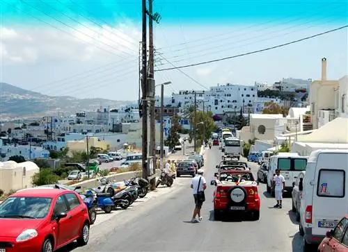 Очередь машин вдоль узкой улицы в Санторини