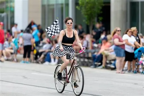 Женщина едет на велосипеде по Пенсильвания-стрит перед парадом Indy 500, Индианаполис, Индиана, Средний Запад, США.