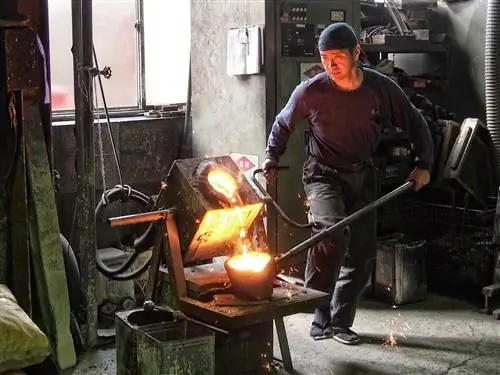 Рабочий по металлу заливает расплавленное железо в форму в мастерской Ивачу.