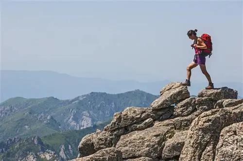 Женщина идет по скалистой местности к вершине Тэчхонбон в национальном парке Сораксан.