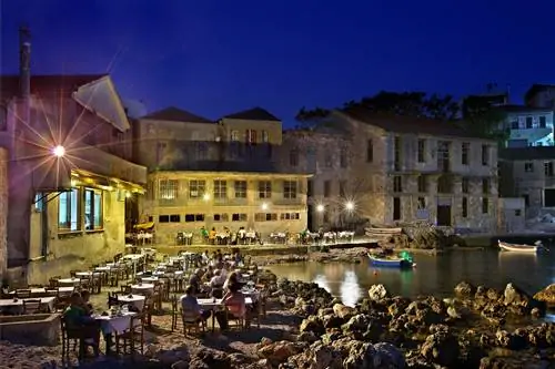 Широкий вид на обедающих на террасе с видом на море ночью в Табакарии, Ханье, Крите, Греции, Средиземном море