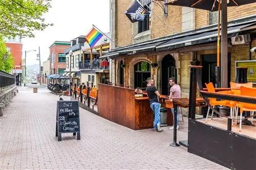 Два человека разговаривают возле паба в районе Сен-Жан-Батист.