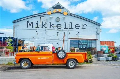 Оранжевый ретро-автомобиль припаркован возле бара Mikkeller на уличном продовольственном рынке Реффен.