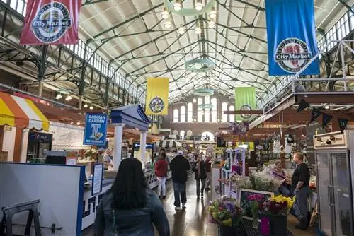 Покупатели идут по городскому рынку в Индианаполисе по дорожке с продуктовыми лавками.