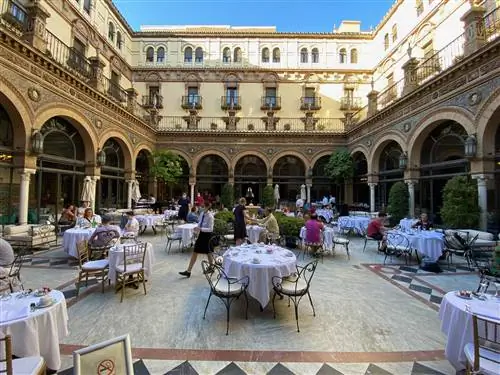 Столы для завтрака во внутреннем дворе исторического отеля Alfonso XIII в Севилье.