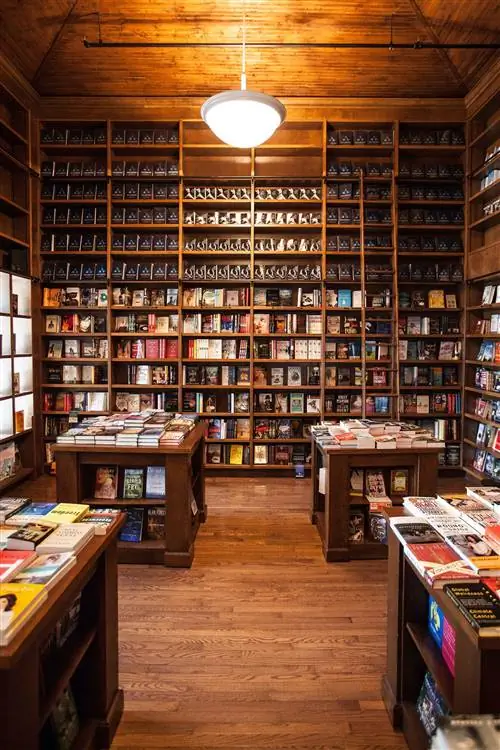 стены с книжными полками из красного дерева, заполненными книгами от пола до потолка в Books & Books в Майами