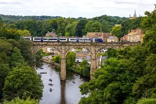 Поезд пересекает впечатляющий виадук Кнаресборо в городе Кнаресборо в Йоркшире.