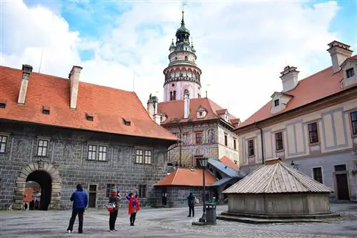 Туристы восхищаются площадью под замковой башней в стиле ренессанс в Чески-Крумлове.