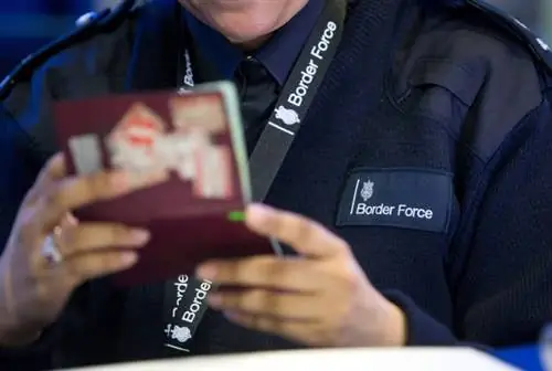 Офицер пограничной службы проверяет паспорта в Терминале 2 терминала Королевы в аэропорту Хитроу, пока вносят паспортные проверки у путешественников, покидающих Великобританию.