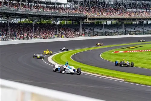 Автомобили участвуют в гонках по гоночной трассе Indianapolis Motor Speedway.