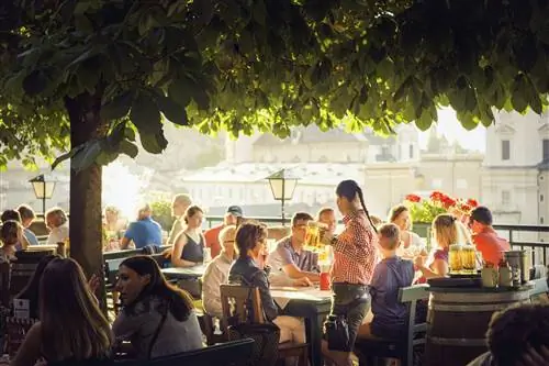 Посетители пьют на солнце в пивном саду Штигкеллера. Зальцбург