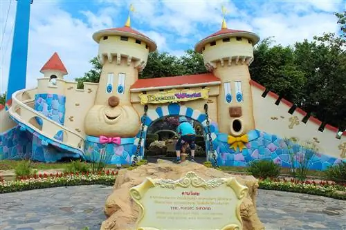 У входа в парк развлечений Dream World в Бангкоке есть большой мультяшный замок с большими улыбающимися лицами, когда ребенок готовится войти.