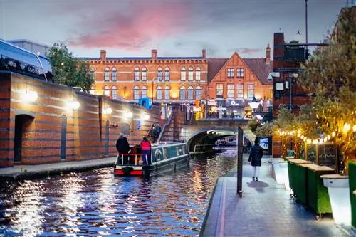 Лодка, плывущая по каналам Бриндли-плейс в Бирмингеме, Великобритания.