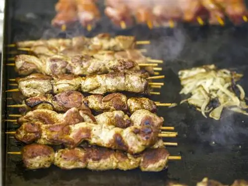 Шашлыки шипят на сковородке на рынке Нашмаркт в Вене
