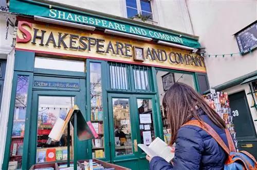 Женщина читает книгу возле книжного магазина Shakespeare and Company в Париже.