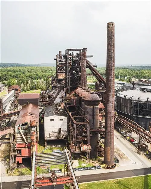 Высокий отдельно стоящий кирпичный дымоход рядом с печью