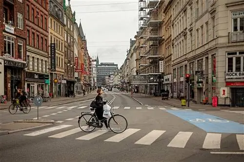 Женщина толкает велосипед по Вестерброгаде в Копенгагене.