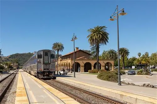 Поезд Amtrak Surfliner подъезжает к железнодорожному вокзалу в стиле миссии в Санта-Барбаре, Калифорния, США.