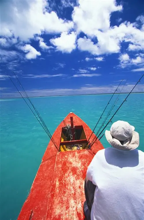 Особенности - Остров Рождества, ловля костей с красной лодки, впереди сидит мужчина.