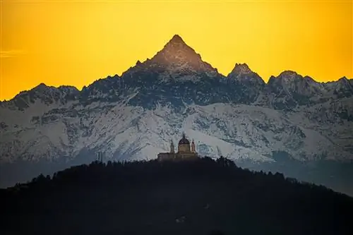 пейзажное фото базилики Суперга с горами Монвизо на заднем плане на закате, отбрасывающими чудесный желтый оттенок