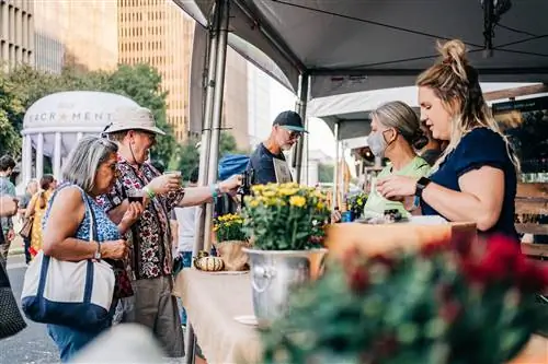 Люди у палатки на фестивале Farm to Fork Festival 2021 в Сакраменто, который проводится в торговом центре Capitol Mall с участием продавцов еды, живой музыки, демонстрационных площадок и многого другого.