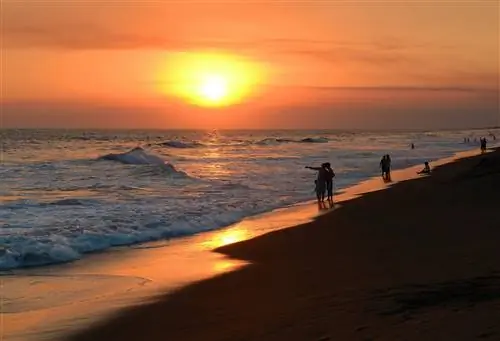 Люди гуляют по пляжу в Монтеррико, Гватемала, на закате