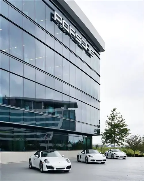 Три белых Porsche выстроились возле стеклянного здания Porsche Experience Center в Атланте.