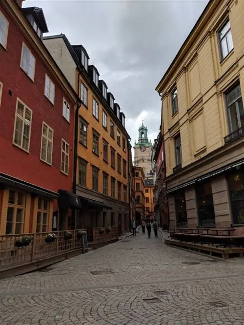 Узкая улица между историческими зданиями, в которой всего несколько человек, в Стокгольме, Швеция; Тихие парки