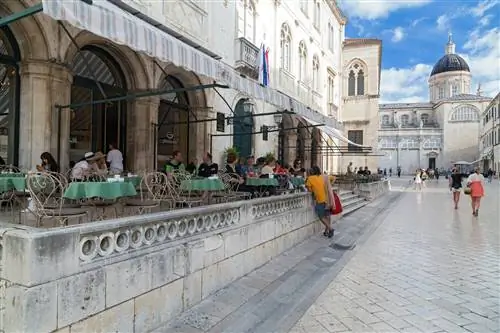 Гости сидят на террасе кафе Gradska kavana в Дубровнике