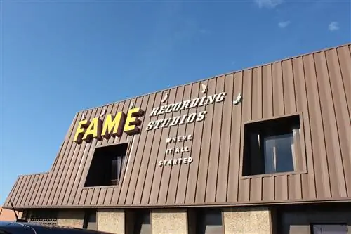 Коричневая линия крыши Fame Studios середины века вырисовывается на фоне голубого неба.