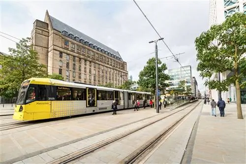 Люди идут к трамваю Metrolink и рядом с ним на площади Святого Петра в Манчестере. Люди идут к трамваю Metrolink и рядом с ним на площади Святого Петра в Манчестере.
