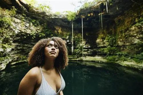 Средний план женщины, осматривающей сенот перед купанием