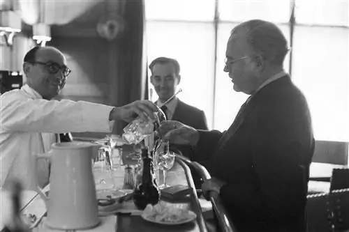 , Эрнест ХЕМИНГУЭЙ на курсах хиппиков д'Отей. Au bar, un serveur en veste blanche sert à boire à l'écrivain.
