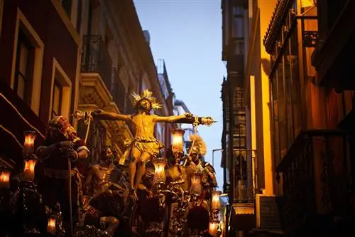 Шествие в сумерках во время Semana Santa в Севилье.