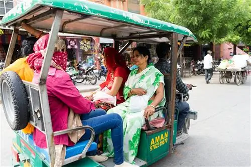 Водитель авторикши (тук-тук) с четырьмя пассажирами на улице в Джайпуре.
