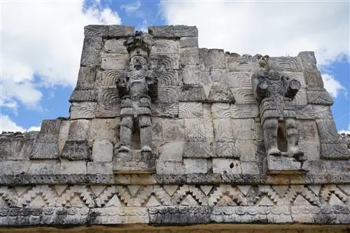 Каменные рельефы богов майя на стороне пирамиды