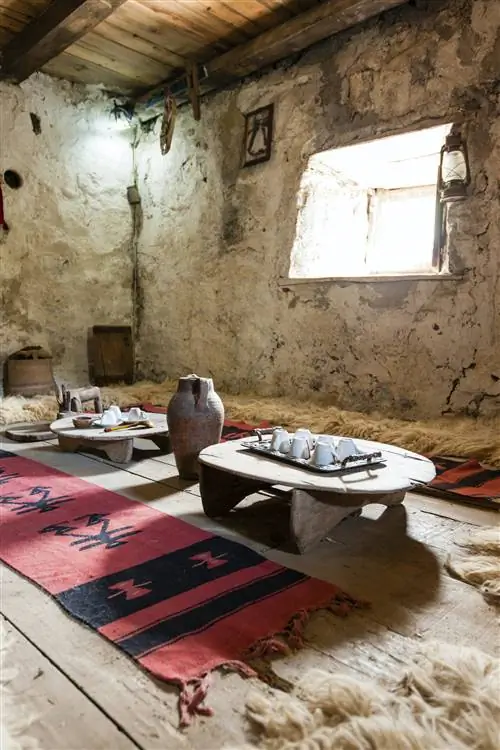 Низкие столики и геометрические коврики, разложенные внутри запертой башни