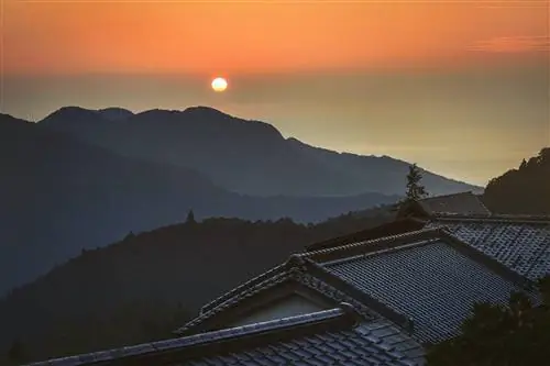 Солнце восходит над темными горами и крышами Нати Тайся.