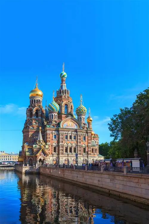 Красочные шпили и золотые купола церкви Спаса-на-Крови в Санкт-Петербурге на фоне ясного голубого неба.