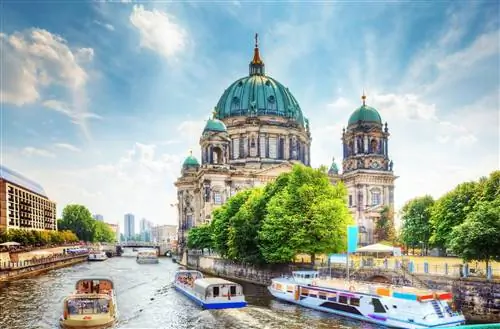 Пассажирские катера дрейфуют по реке Шпрее в солнечный день. Виден Berliner Dom (Берлинский собор).