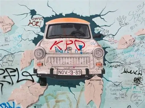 Изображение автомобиля, пробившего стену в галерее Ист-Сайд в Берлине.