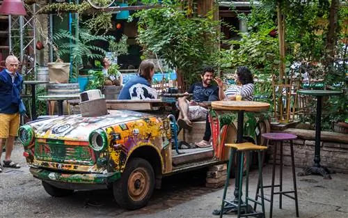 Посетители наслаждаются напитком в Szimpla Kert, известном руин-баре в Будапеште.