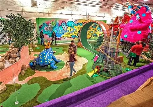 Вид с воздуха на поле для мини-гольфа в Can Can Wonderland, на котором есть новые объекты, такие как гигантская лягушка и большая структура «петля за петлей».