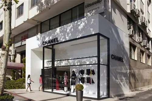 Два человека входят в магазин Chanel в престижном районе Нишанташи в Стамбуле. Магазин имеет элегантный черно-белый фасад.