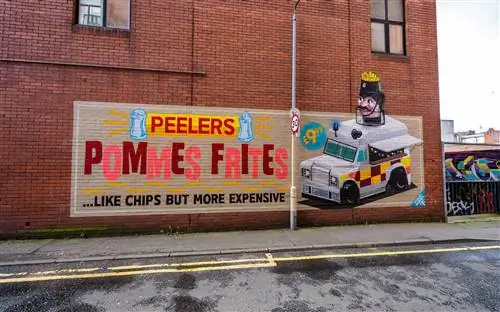 Стена из красного кирпича, украшенная красочной фреской с рекламой Peeler's Pommes Frites в стиле старинного плаката.