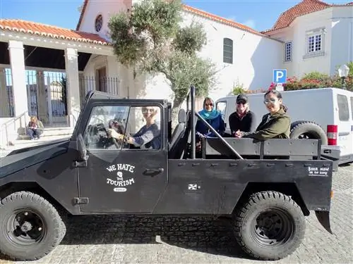 Черный джип с открытым верхом в Лиссабоне с надписью «Мы ненавидим туризм» сбоку.