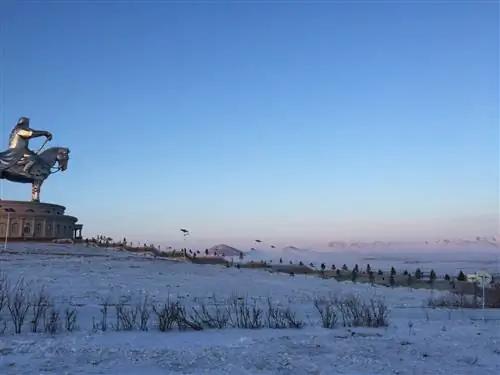 Гигантская статуя Чингисхана, изображающая человека на лошади, смотрит на зимнюю степь.