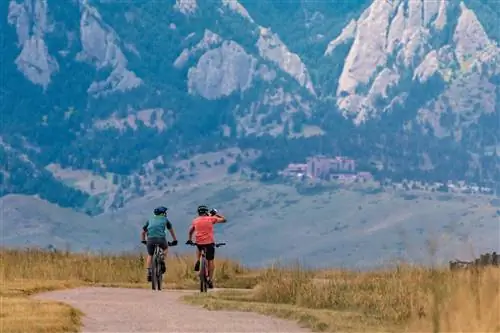 Два байкера едут по долине Боулдер рано утром.